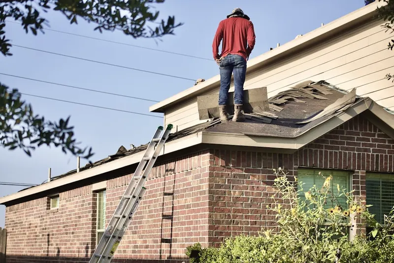 Professional roofer working on a residential roof in Washington Park